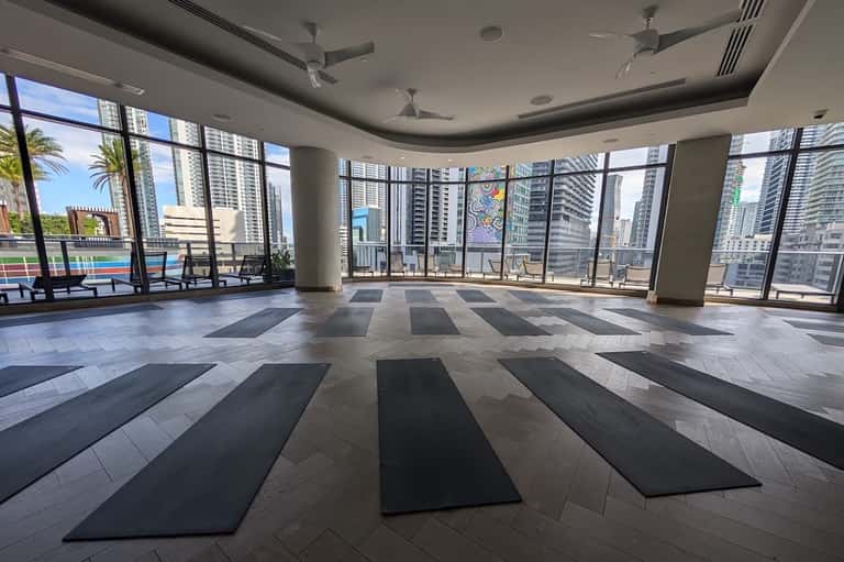 High-rise yoga studio with panoramic city views, floor mats, and floor-to-ceiling windows