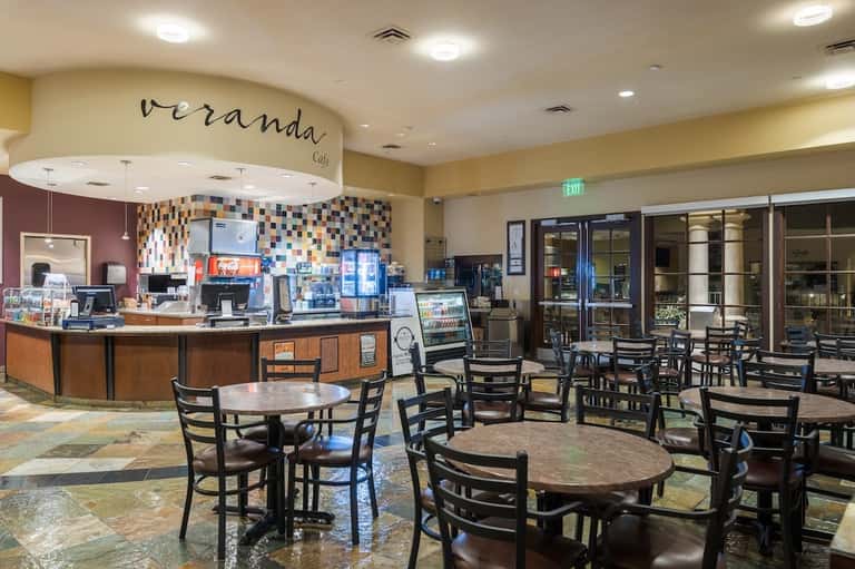 Hotel café interior with counter service, colorful mosaic backsplash, seating area, and welcoming hospitality design