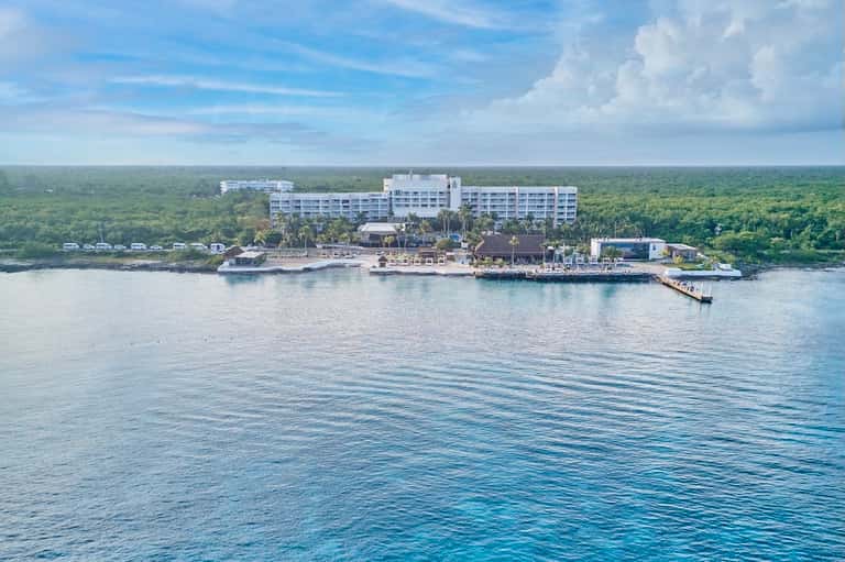 Beachfront all-inclusive resort with white building surrounded by lush tropical jungle