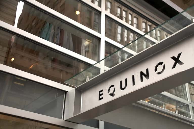 Equinox spa entrance with glass storefront and modern signage in urban setting