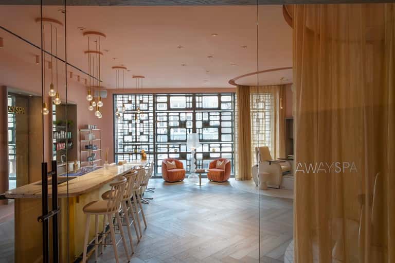 Luxury spa reception area with geometric wall panels, modern furnishings, and elegant design