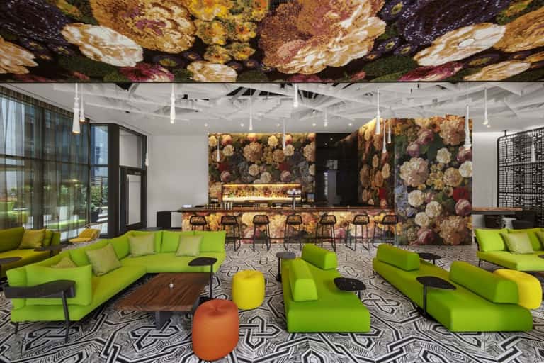 Modern hotel lobby lounge with lime-green seating and floral ceiling design