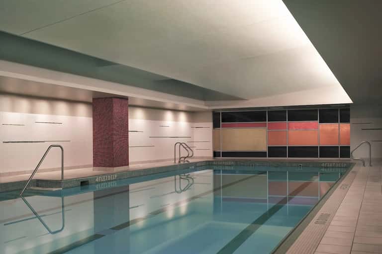 Modern indoor swimming pool with 4-foot depth marker and minimalist design