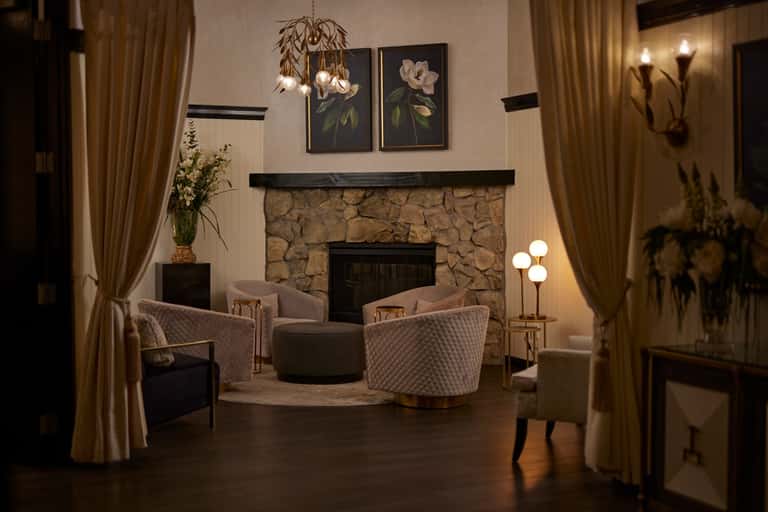 Elegant fireplace lounge with upholstered seating and warm ambient lighting
