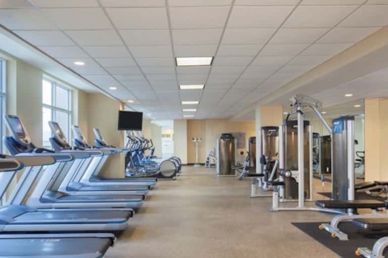 Fitness center with treadmills, exercise equipment, and large windows for natural light