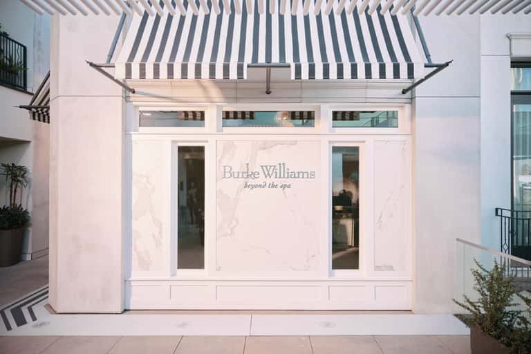 Elegant pink storefront with Burke Williams branding and navy striped awning
