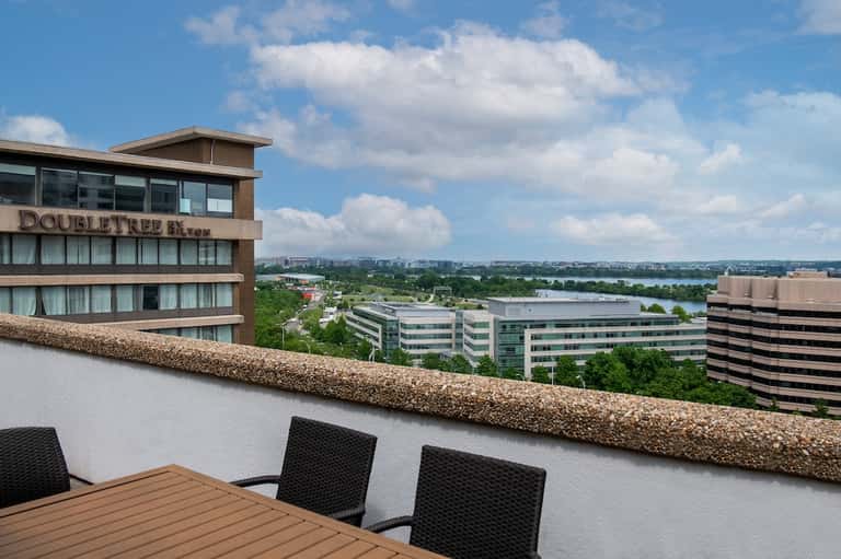 Rooftop terrace view of DoubleTree hotel overlooking river, cityscape, and green landscape
