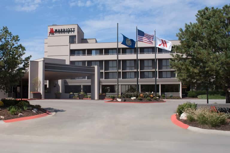 Marriott hotel exterior with modern architecture, entrance portico, and American flags displayed