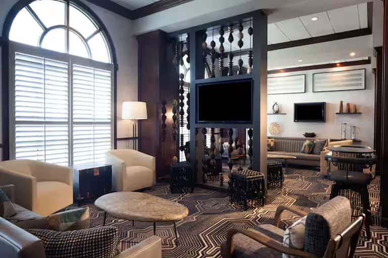 Elegant hotel suite with contemporary furnishings, dark accents, and arched windows