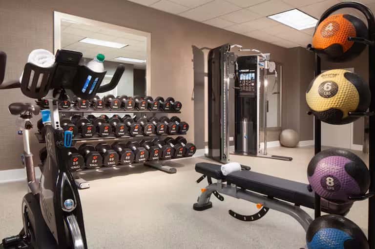 Fitness center with dumbbell rack, exercise bike, medicine balls, and weight training equipment