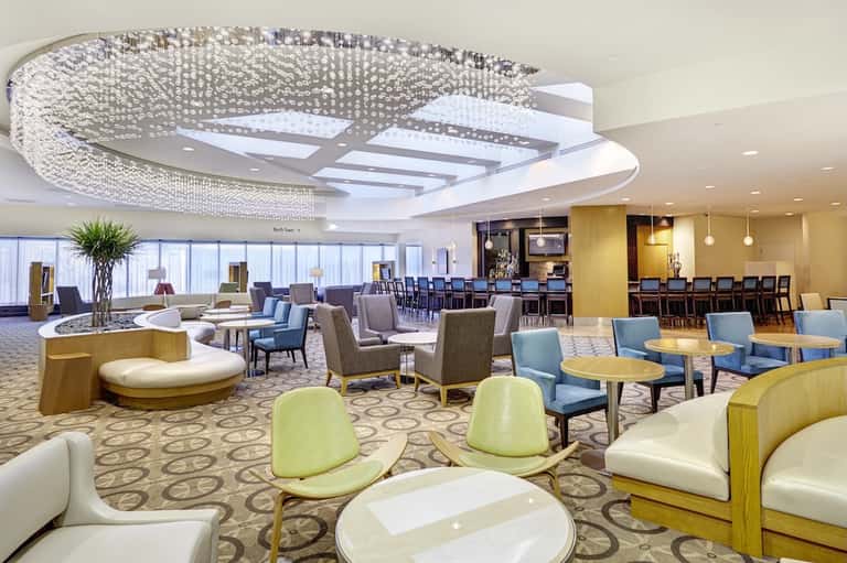 Upscale hotel lounge with crystal chandelier, seating areas, and panoramic windows