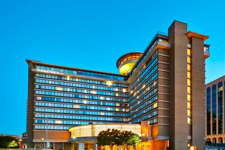Contemporary DoubleTree hotel exterior at dusk with illuminated facade and rounded architectural features