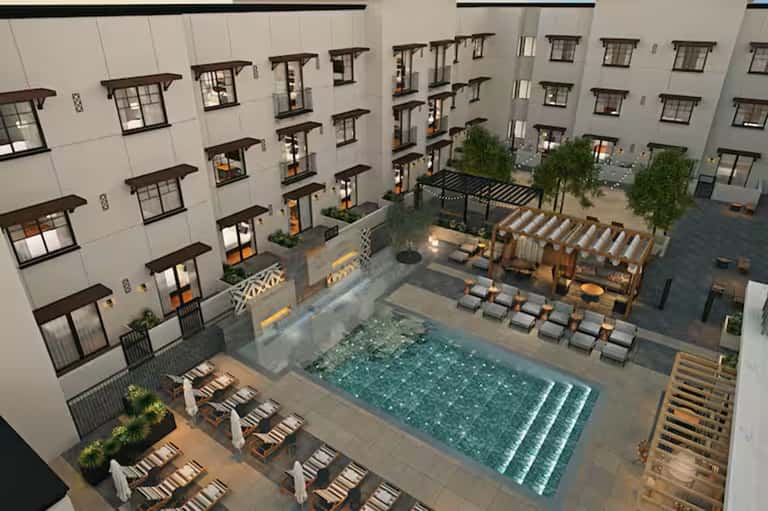 Aerial view of resort courtyard pool surrounded by multi-story residential buildings