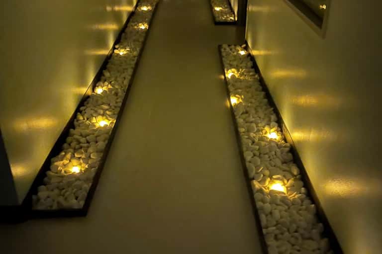 Illuminated hallway with decorative white stone features and warm accent lighting in hotel corridor