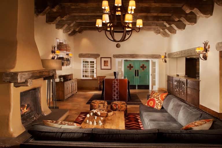 Rustic lodge lobby with fireplace, exposed beams, wooden furniture, and southwestern decor