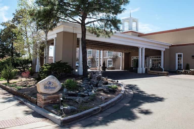 Hilton hotel entrance with white columns, covered portico, and manicured grounds