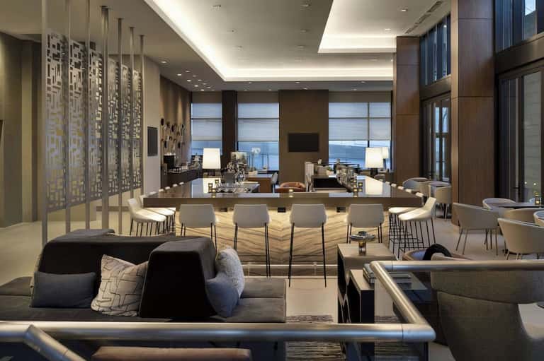 Modern resort lounge with ocean view, geometric wall art, bar counter, and contemporary furnishings