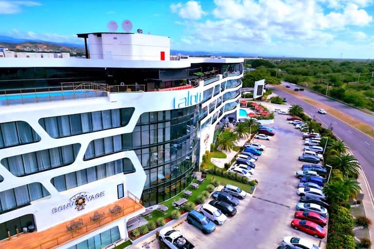 Aerial view of multi-story beachfront resort with parking lot and ocean views