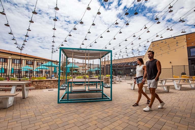 Outdoor recreation area with hanging shoes art installation and covered swing structure