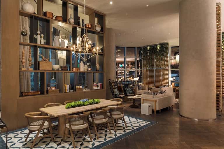 Upscale resort common area with dining table, shelving, lounge seating, and modern design