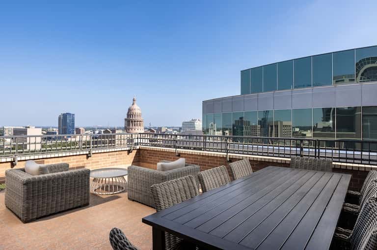Upscale rooftop terrace with city views of capitol building and wicker furniture