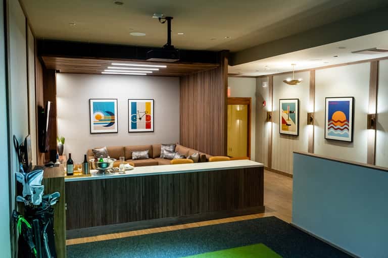 Modern hotel reception desk with colorful artwork, wood paneling, and welcoming lounge area