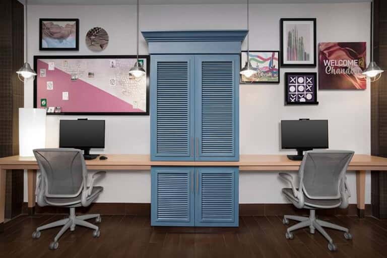 Modern business center with two workstations, blue storage cabinet, and contemporary lighting