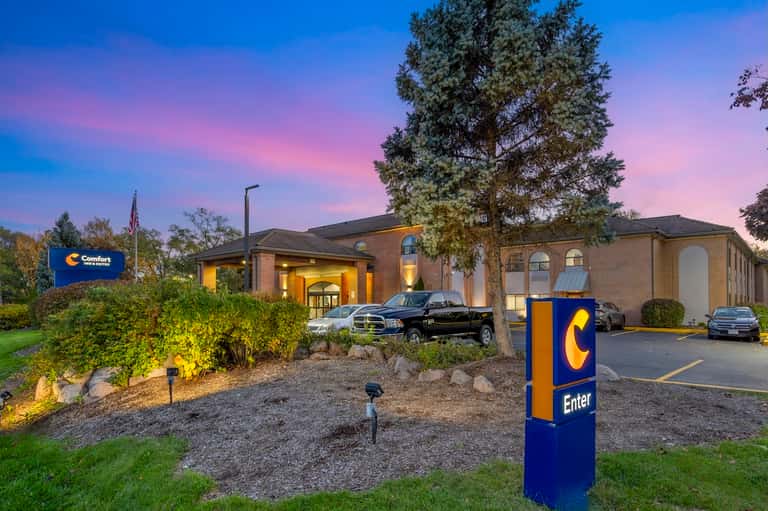 Comfort Inn hotel exterior at dusk with brick facade, landscaping, and illuminated entrance