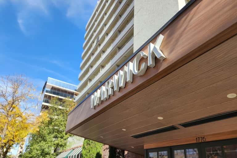 Hotel exterior signage for Marriott with modern wood cladding and multi-story building against blue sky