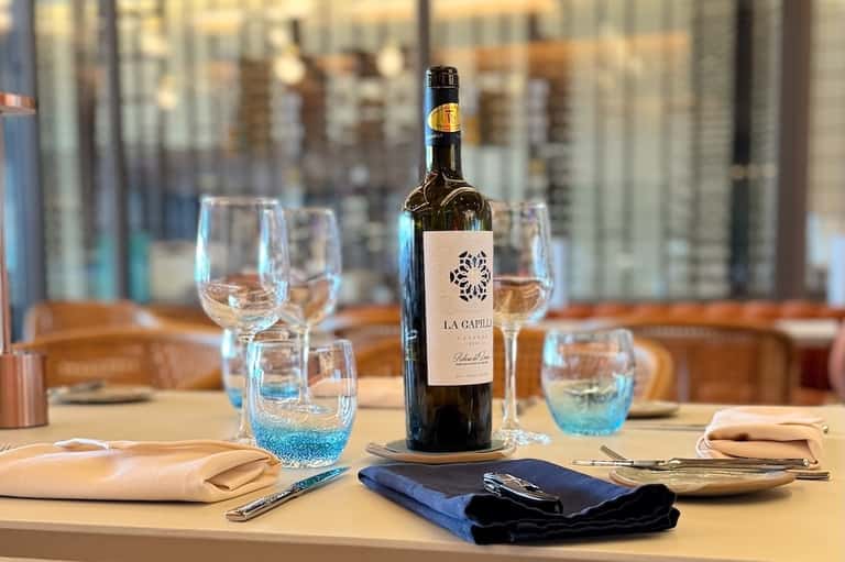 Upscale restaurant table setting with wine bottle and place settings overlooking city
