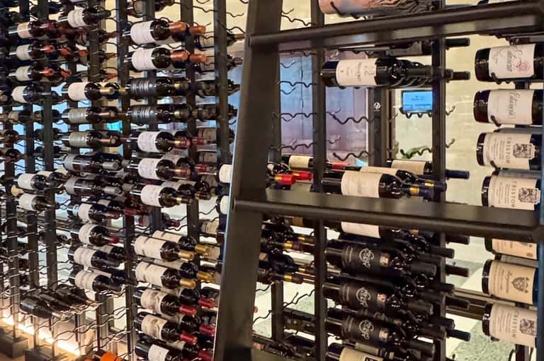 Wine cellar storage with extensive collection of bottles displayed on metal racks