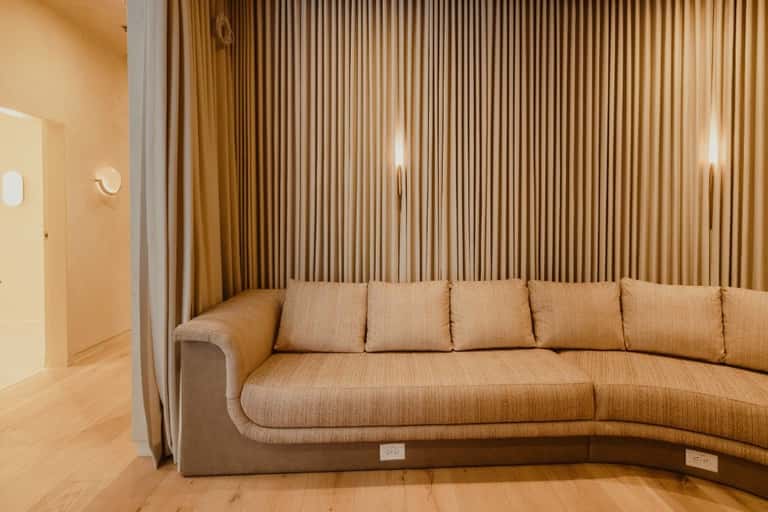 Curved beige upholstered sectional sofa in warm-toned contemporary living space