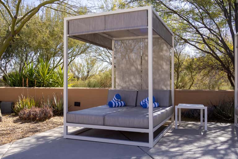 Modern canopy daybed on outdoor terrace with blue and white striped cushions