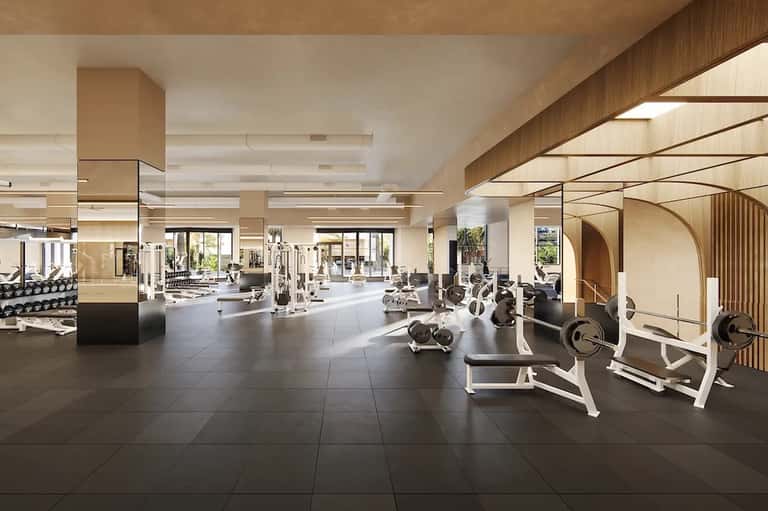 Spacious modern fitness center with cardio equipment, weights, and bright natural lighting throughout