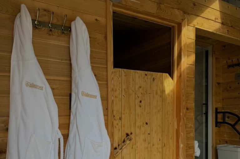 Wooden sauna interior with hanging towels and bench seating