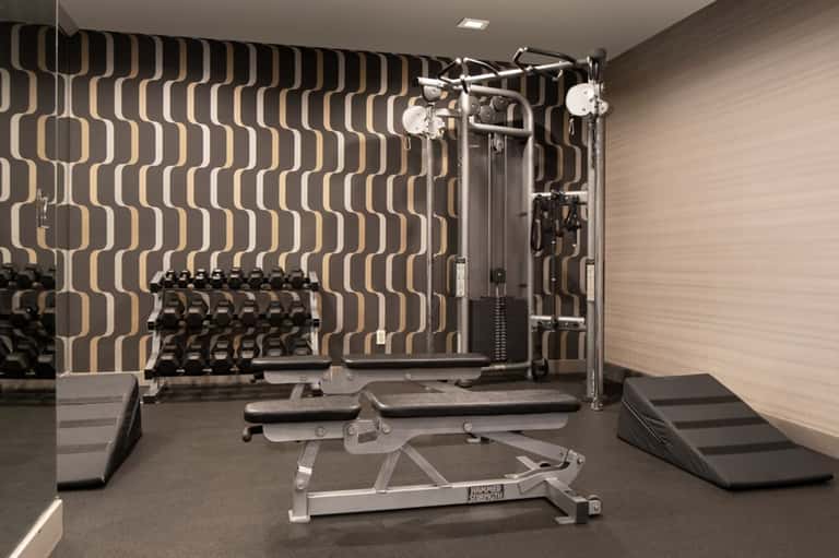 Modern resort fitness center with geometric patterned walls and strength training equipment