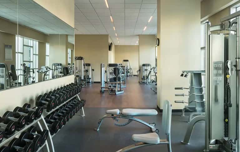Well-equipped fitness center with dumbbells, machines, and mirrored walls