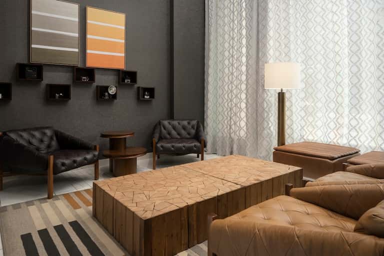 Modern spa relaxation lounge with black leather seating, wood tables, and neutral decor