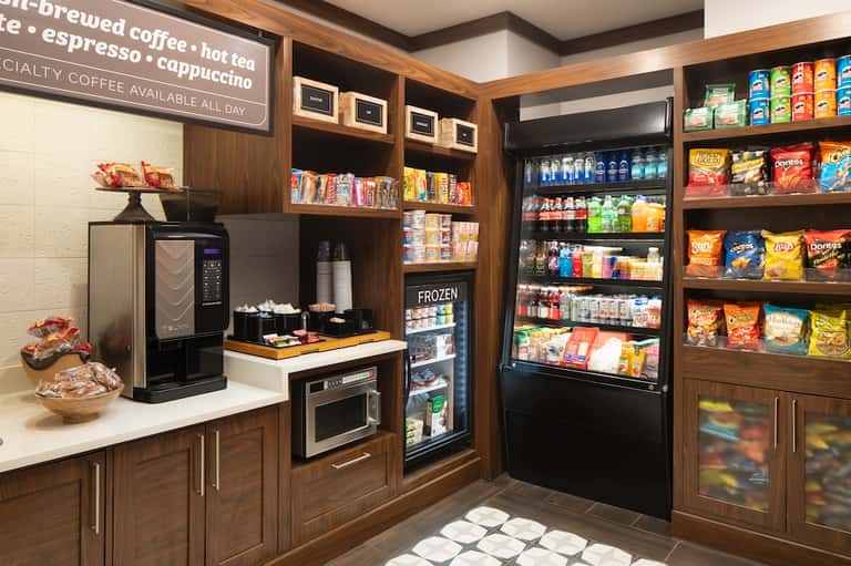 Hotel convenience shop with coffee bar, refrigerated beverages, snacks, and packaged goods