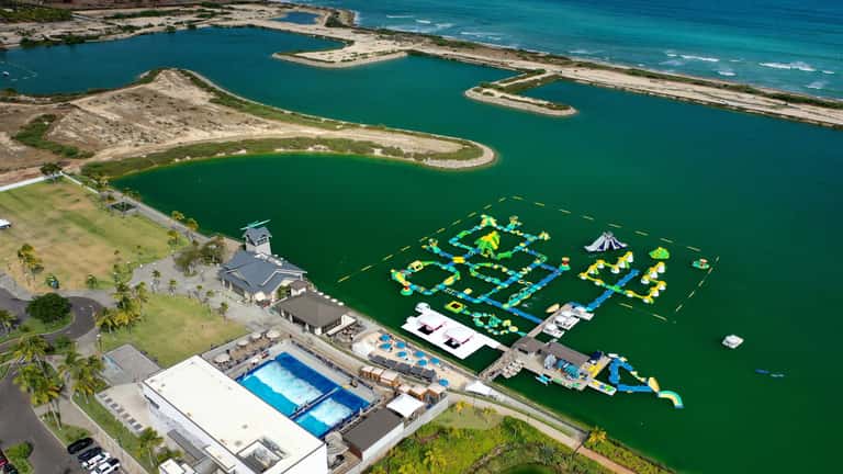 Aerial view of resort with pools, inflatable water park, and turquoise lagoon