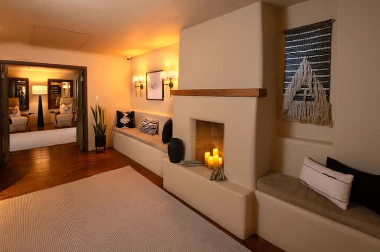 Elegant spa suite entrance with warm lighting, fireplace nook, and luxurious decor details