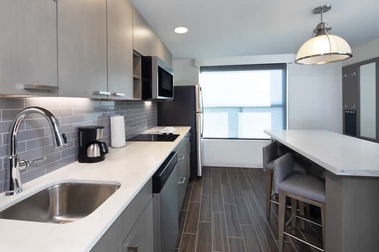 Contemporary kitchen with gray cabinets, subway tile backsplash, and stainless appliances