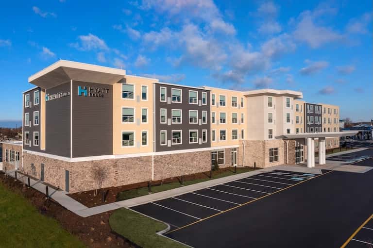 Hyatt House multi-story hotel exterior with mixed material facade and parking lot.