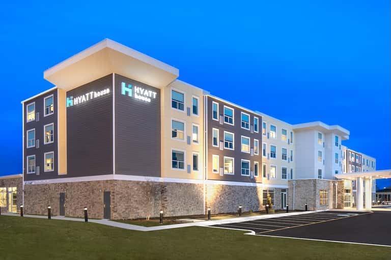 Contemporary Hyatt House hotel exterior at dusk with illuminated windows and manicured grounds