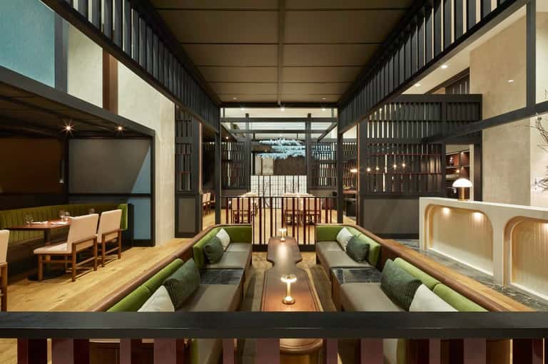 Modern lounge area with seating, fireplace, and glass doors opening to outdoor terrace