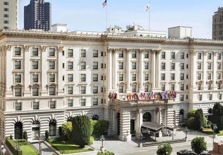 Historic Beaux-Arts building facade with classical columns, arched windows, and international flags