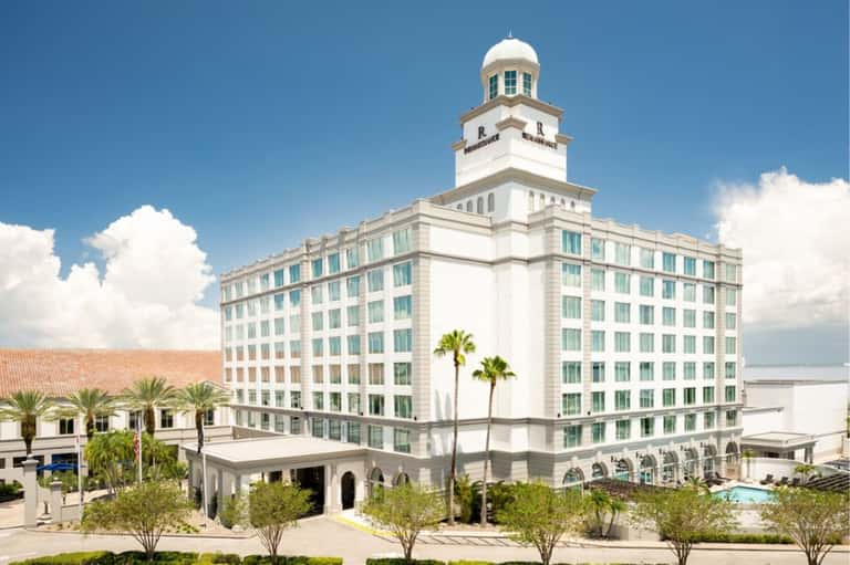 Historic beachfront hotel exterior with white neoclassical architecture and landmark tower