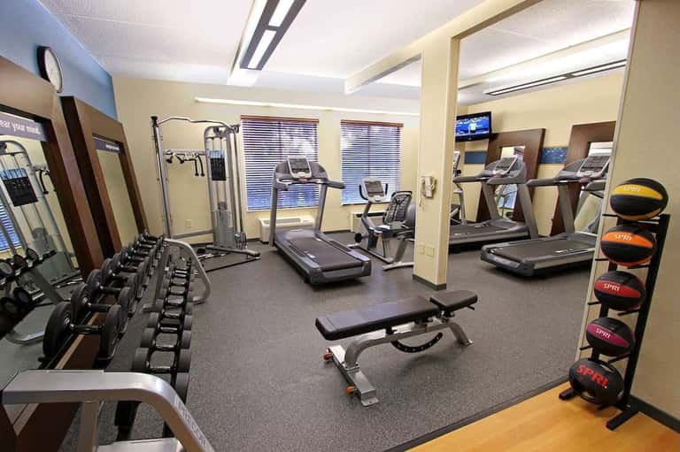 Fitness center with treadmills, dumbbells, weight machines, and exercise equipment