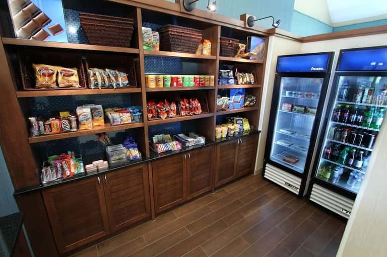 Resort snack bar and beverage center with shelving, refrigerators, and packaged refreshments