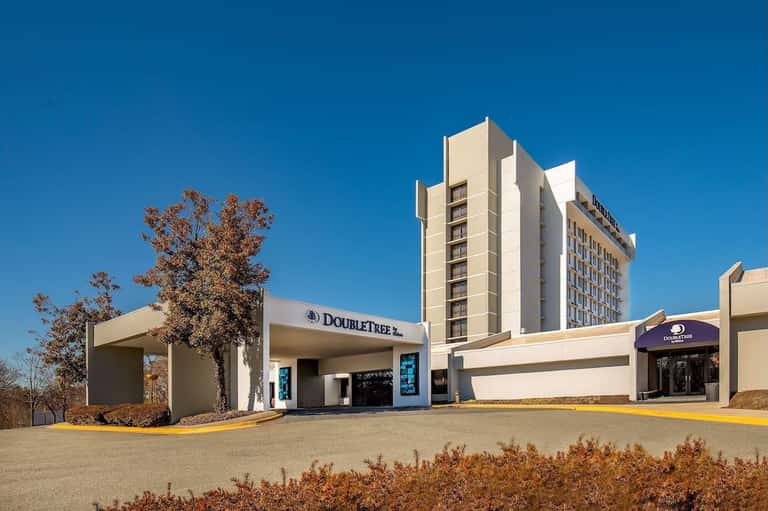 DoubleTree hotel exterior with modern architecture, landscaping, entrance, and clear blue sky